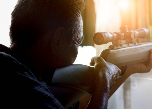 man approaching to shoot long rifle weapon