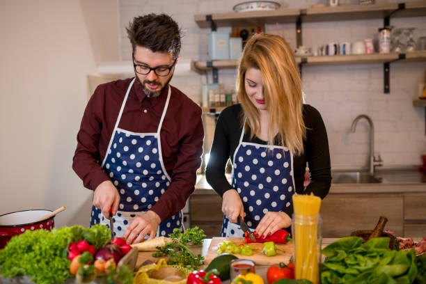 istock Smiling young couple cooking food in the kitchen 936381144
