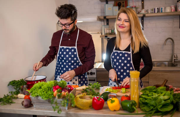 istock Smiling young couple cooking food in the kitchen 936381342