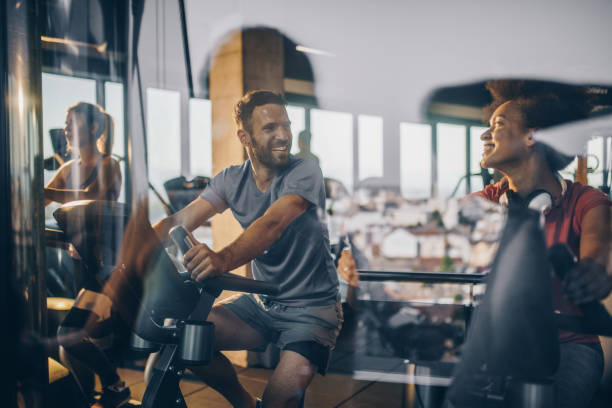 счастливые спортсмены общаться во время тренировки в тренажерном зале вместе. - exercising sport gym spinning стоковые фото и изображения
