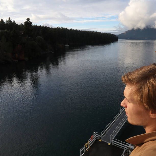 istock Young man looking off from ferry boat 936382244
