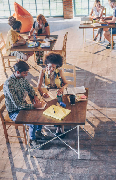 istock Above view of college students learning in the library. 936382712