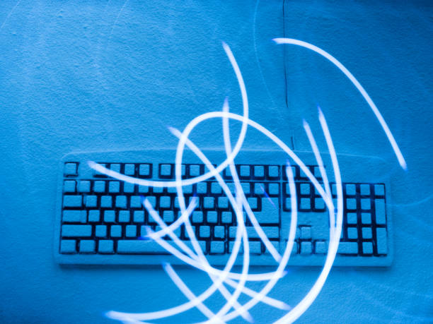 istock keyboard covered with snow lit with blue light with traces chaotically located from drawing by light 936383154