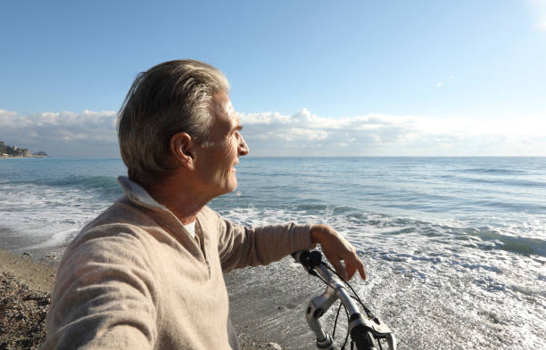istock Man relaxes with bike, at beach 936383474