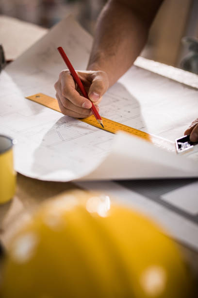 istock Unrecognizable male architect making measurements and drawing on housing project. 936384944