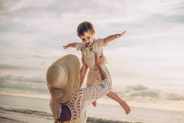istock Playful mother and son having fun on the beach. 936385986