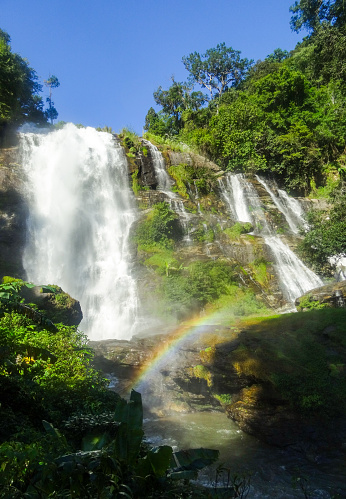 a waterfall in Thailand with a rainbow below