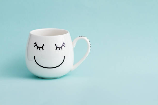 istock Smiling White Coffee Mug on Green Background 936387374