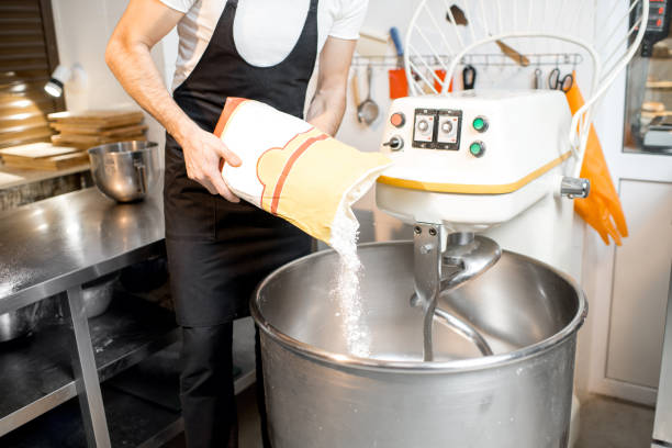 Filling flour into the kneader at the bakery