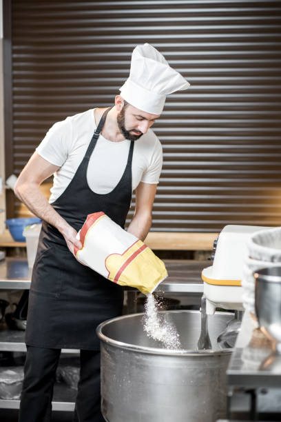 istock Baker filling flour into the kneader 936388494