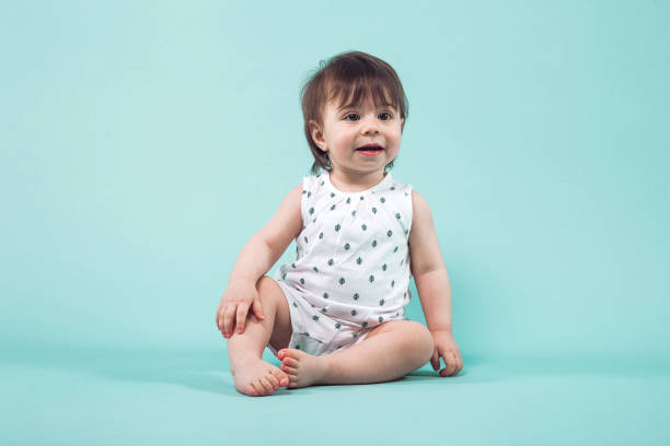 istock Cute small girl crawling sitting in studio on blue background 936390450
