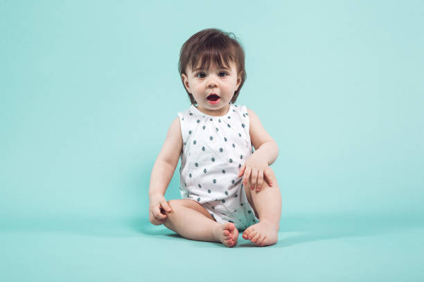 istock Cute small girl crawling sitting in studio on blue background 936390464