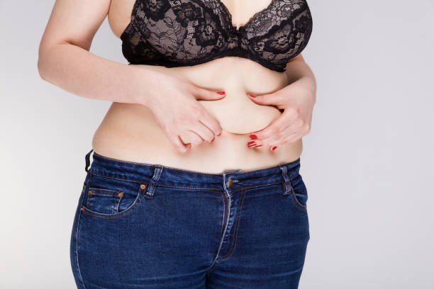 istock Overweight woman measuring her belly 936391390
