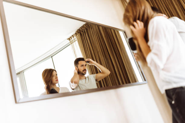 istock couple combing the hair at the mirror 936392110