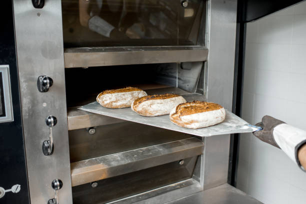 istock Taking off the breads from the oven 936392300