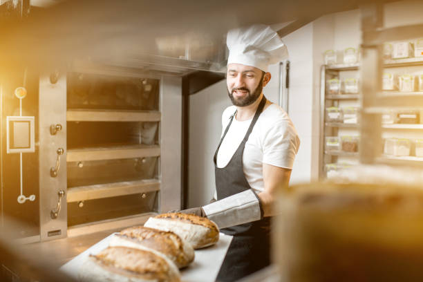 istock Baker with baked breads at the bakery 936392678