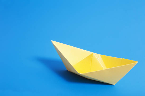istock paper boat on blue paper background 936393706