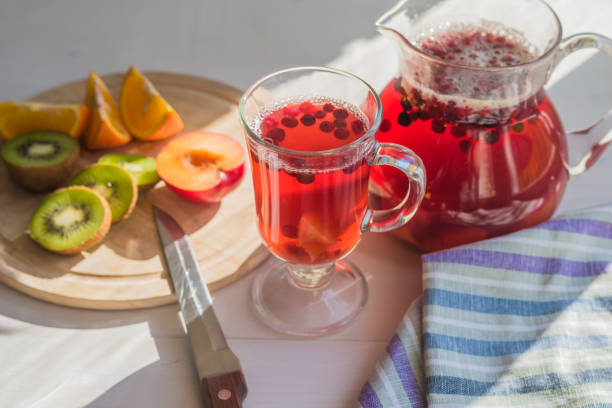 istock Compote of red berries in a pitcher and a glass, fresh fruit on a rustic table 936394734