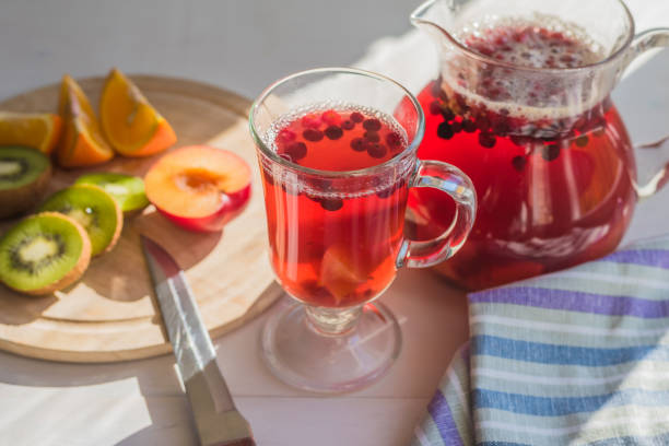 istock Compote of red berries in a pitcher and a glass, fresh fruit on a rustic table 936394758