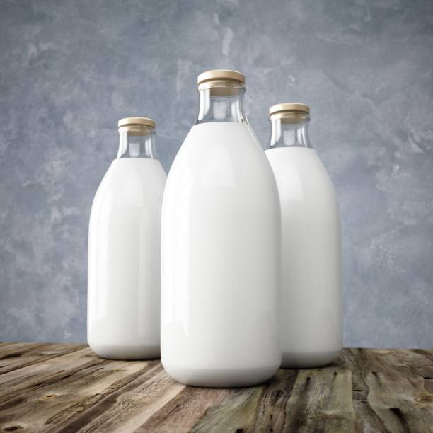istock 3D rendering glass milk bottles on wooden table 936397200