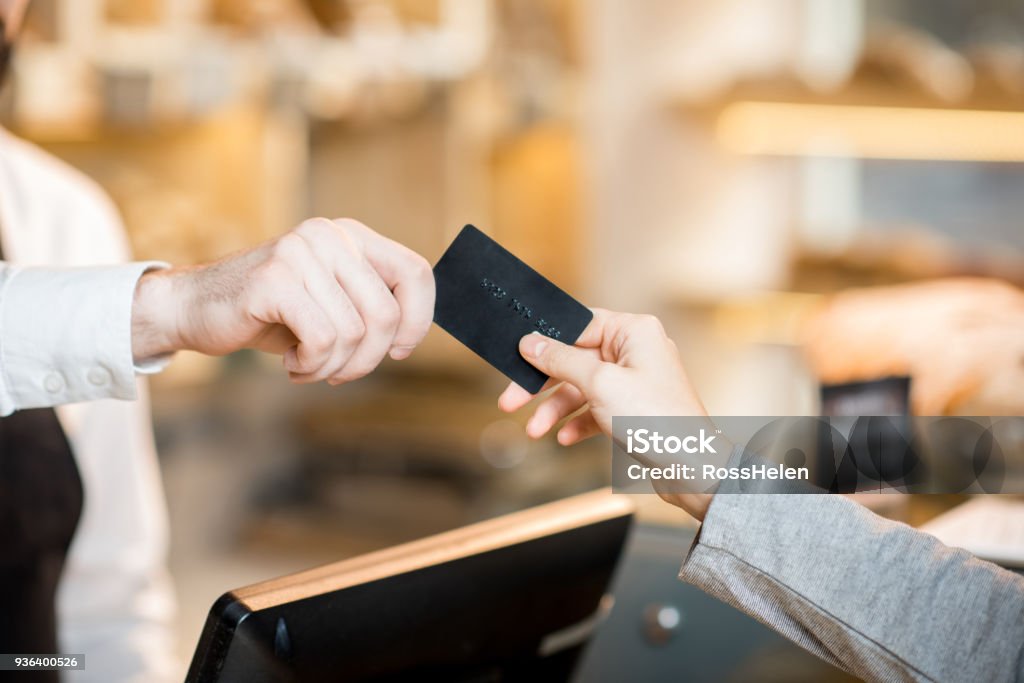 Pagando con tarjeta de crédito en la tienda con productos de panadería - Foto de stock de Tarjeta de crédito libre de derechos