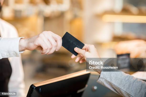 Pagando Con Tarjeta De Crédito En La Tienda Con Productos De Panadería Foto de stock y más banco de imágenes de Tarjeta de crédito