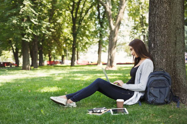 istock Young pensive woman using laptop in park 936401056