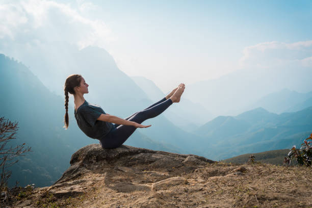 istock Woman training yoga on mountain cliff 936401466