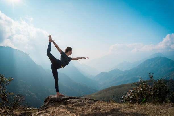 frau training yoga, berge im hintergrund - yoga stock-fotos und bilder