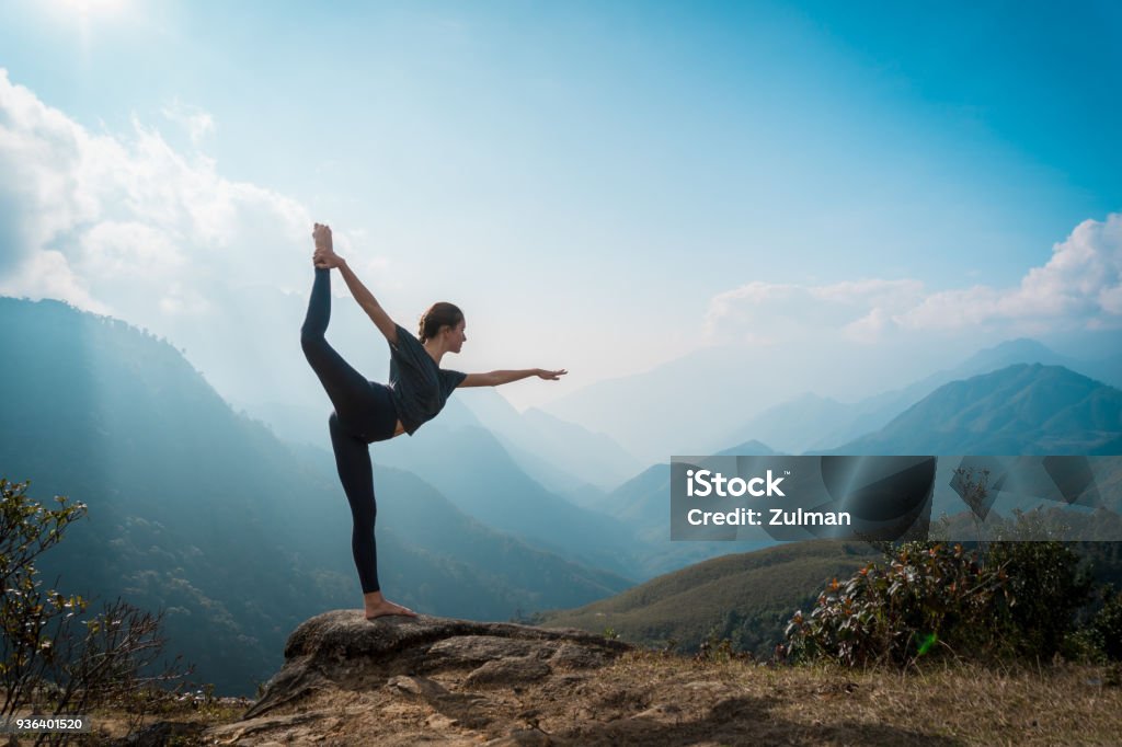 Woman training yoga, mountains on background Woman training yoga at sunrise, mountains on background Yoga Stock Photo