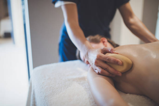 istock Masseur massaging masseuse at wellness resort 936401734