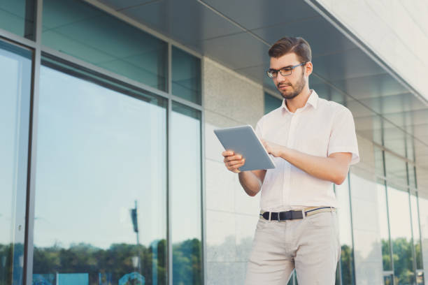 istock Pensive businessman using tablet outdoors 936401978