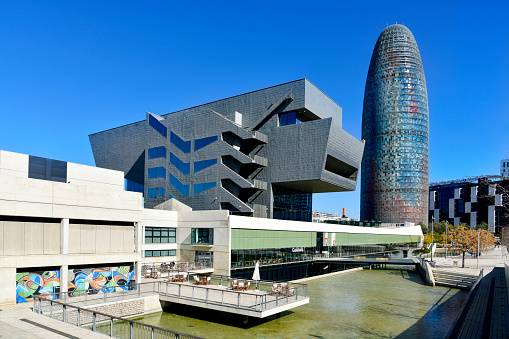 Barcelona, Spain - March 8, 2018: The Disseny Hub Barcelona museum and the Torre Glories, formerly known as Torre Agbar, designed by the famous architect Jean Nouvel, in the background