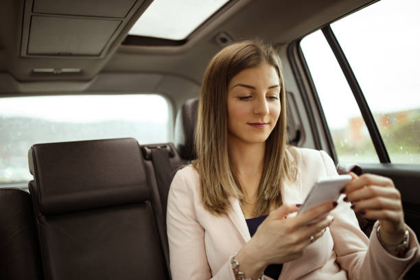 istock Young woman using mobile in car 936402518