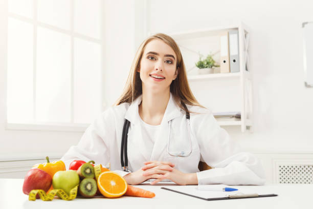 istock Nutritionist desk with fruit and measuring tape 936403798