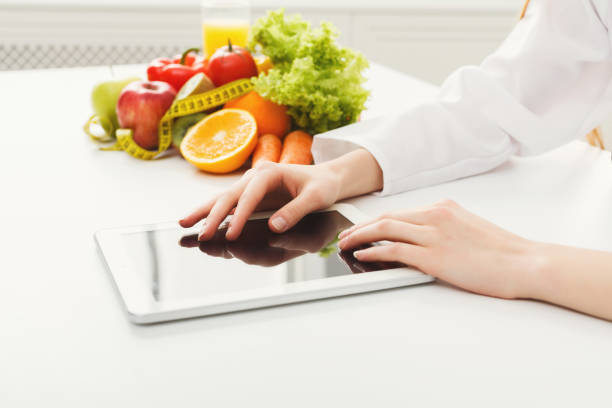 istock Female nutritionist working on digital tablet 936403842