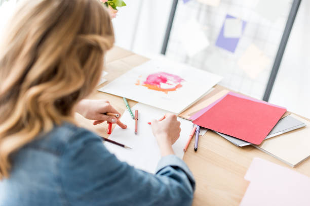 istock back view of magazine editor drawing sketches at workplace 936404162