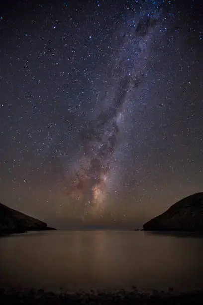 the milky way, or emu in the sky, over a bay in the banks Peninsula region of New Zealand’s South Island.