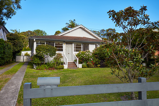 Australian house from fence in suburbs against sky.