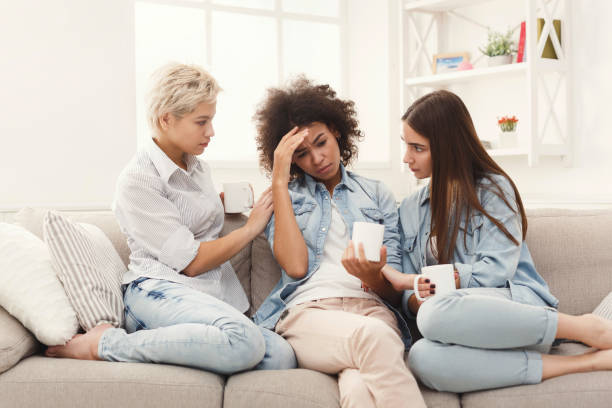 istock Three young female friends chatting at home 936404702