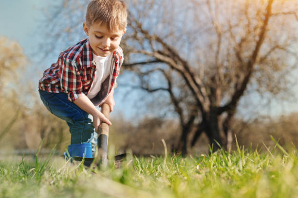 istock Enthusiastic little boy digging the ground in the garden 936407216