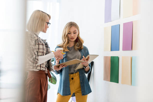 istock fashionable magazine editors working with documents at color palette on wall 936407754