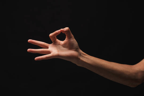 istock Male hand picking up something, cutout at black 936407756