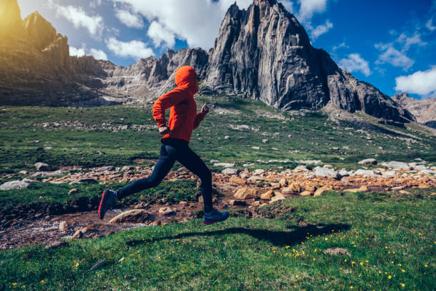 istock woman trail runner running on beautiful mountains 936409564
