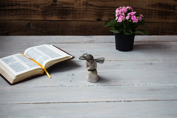 istock angel and the open bible and flowers 936409838