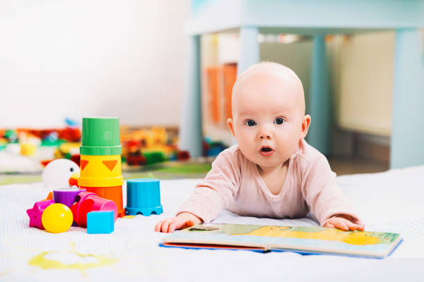 bebé adorable 6 meses buscando y leyendo un libro. - playing playful baby contemporary fotografías e imágenes de stock