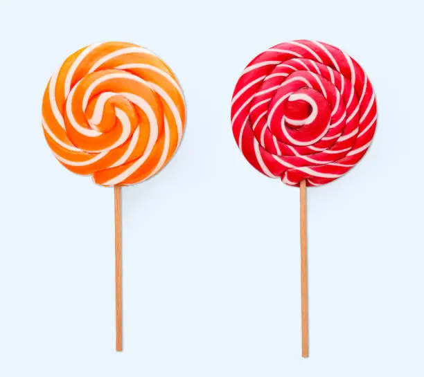Photo of Spiral lollipops on white background. Colorful candies, isolated