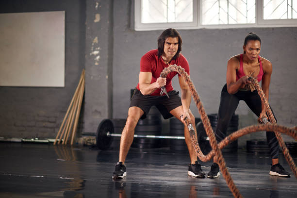 istock Man and woman working out with ropes 936413302