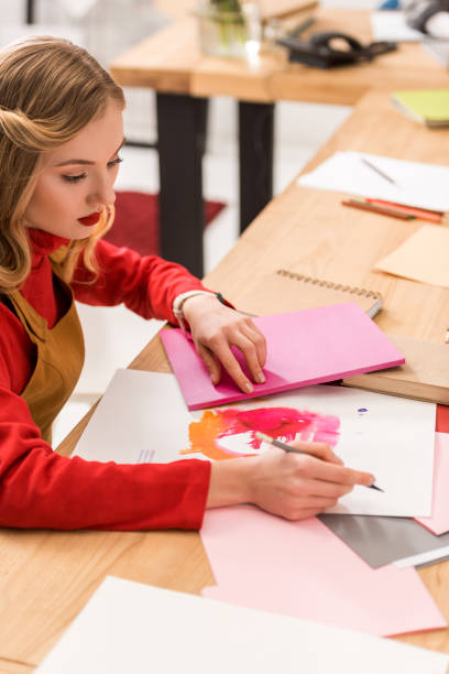 istock attractive fashion magazine editor working with sketches and documents in modern office 936415554