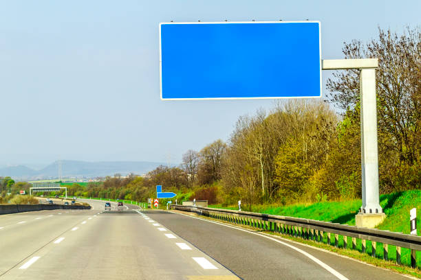 istock Blank blue freeway sign over the road on sunny day 936415654